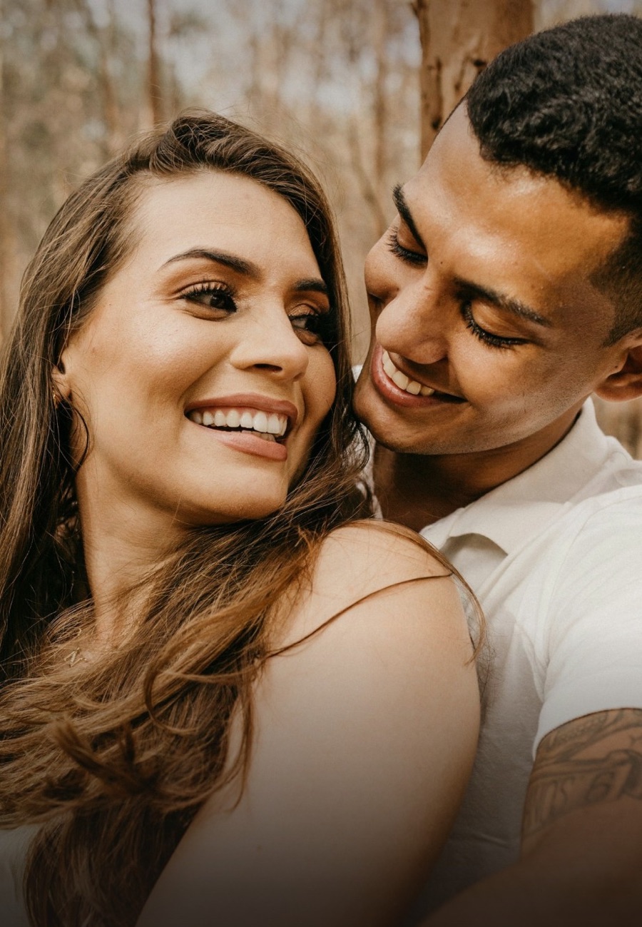 A smiling couple embracing outdoors